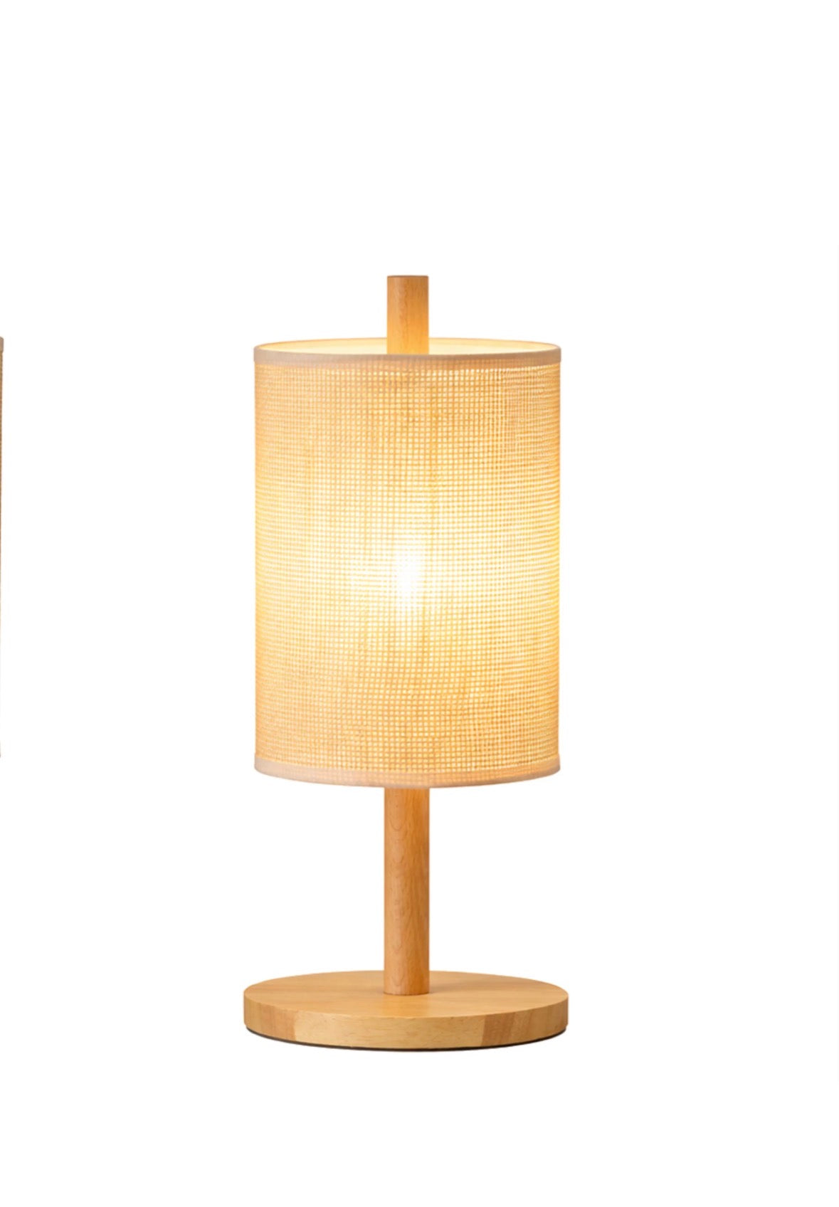 The Aria table lamp lit on a side table in a living room
