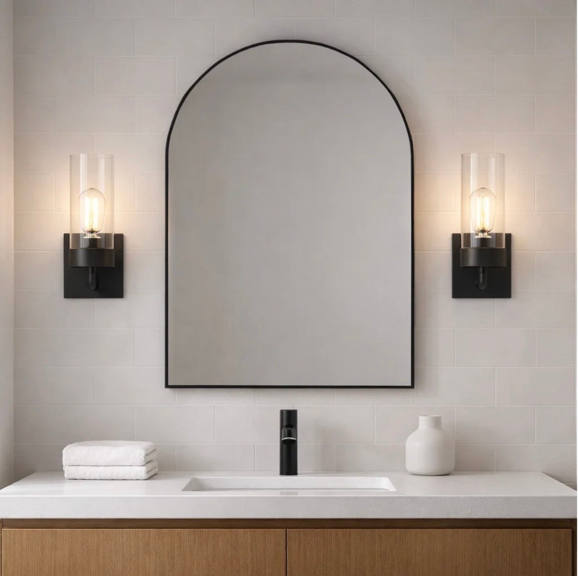The Zephyr wall sconces flanking an arched mirror in a bathroom – lit