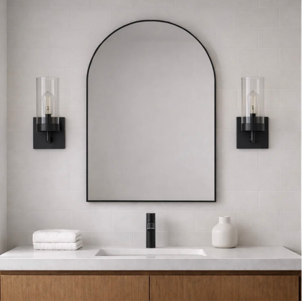 The Zephyr wall sconces flanking an arched mirror in a bathroom – unlit