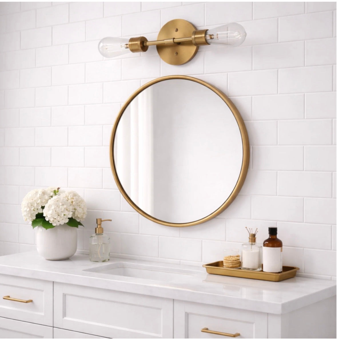 The Aurelia satin brass single-light sconces flanking an oval mirror in a neutral bathroom