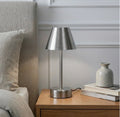 The Lumière brushed nickel cordless LED table lamp unlit on a wooden nightstand